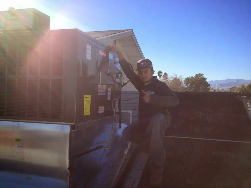 HVAC technician performing AC Tune-Up on a rooftop unit in Old Lyme
